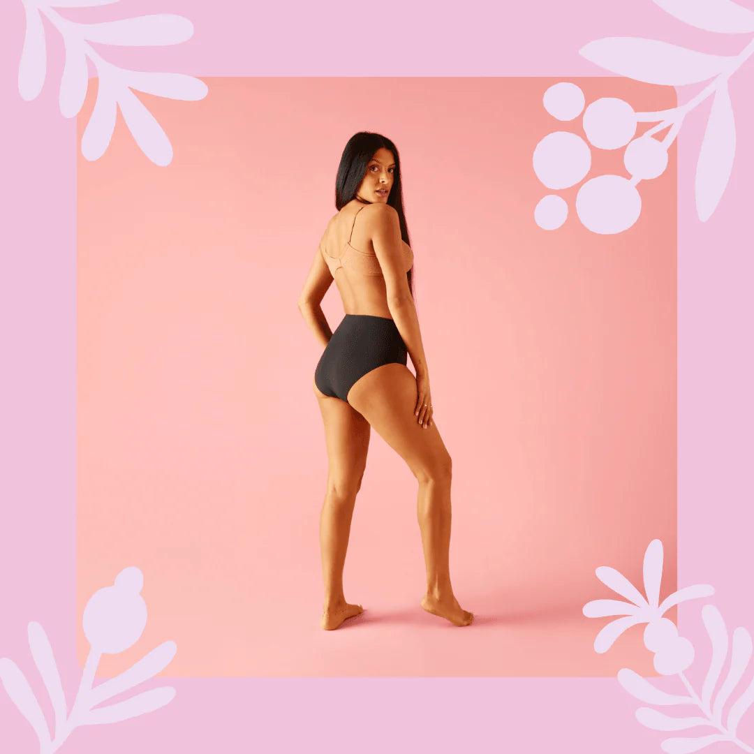 Woman seen wearing Bodyform High Waist Heavy Flow Washable Period Pants in black, minimalist white background.