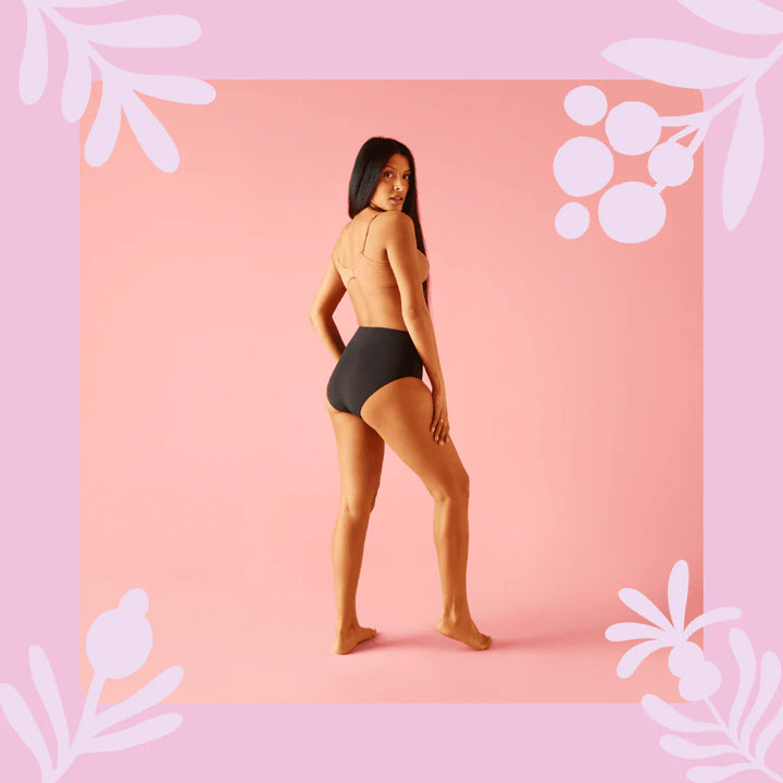 Woman seen wearing Bodyform High Waist Heavy Flow Washable Period Pants in black, minimalist white background.
